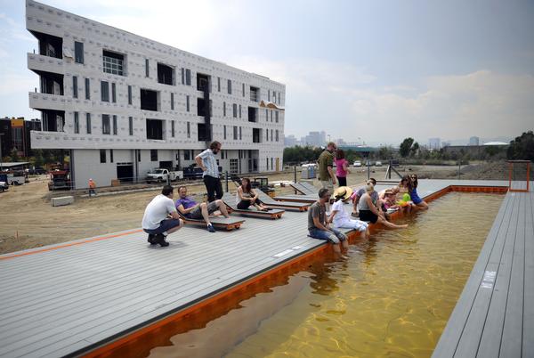 The swimming pool at the TAXI development in Denver is made from two shipping containers welded together. Residents and employees at the development gather on a 100 degree day on the deck around the lap pool on Friday, June 29, 2012. Cyrus McCrimmon, The Denver Post